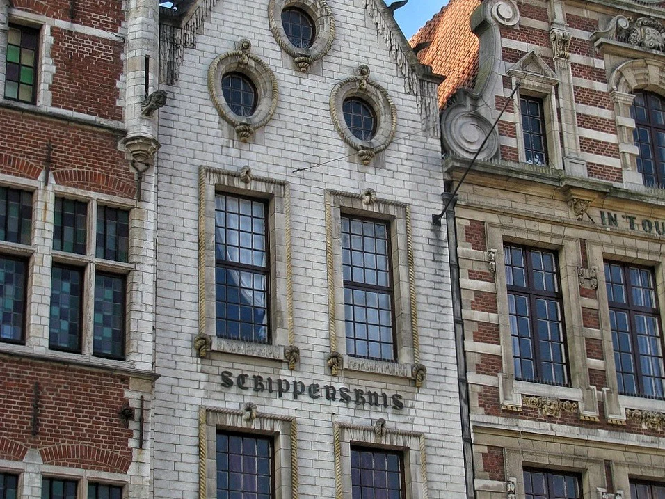Ayuntamiento gótico de Lovaina con estudiantes en la plaza, ciudad universitaria belga